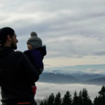 Dad holding baby overlooking mountains